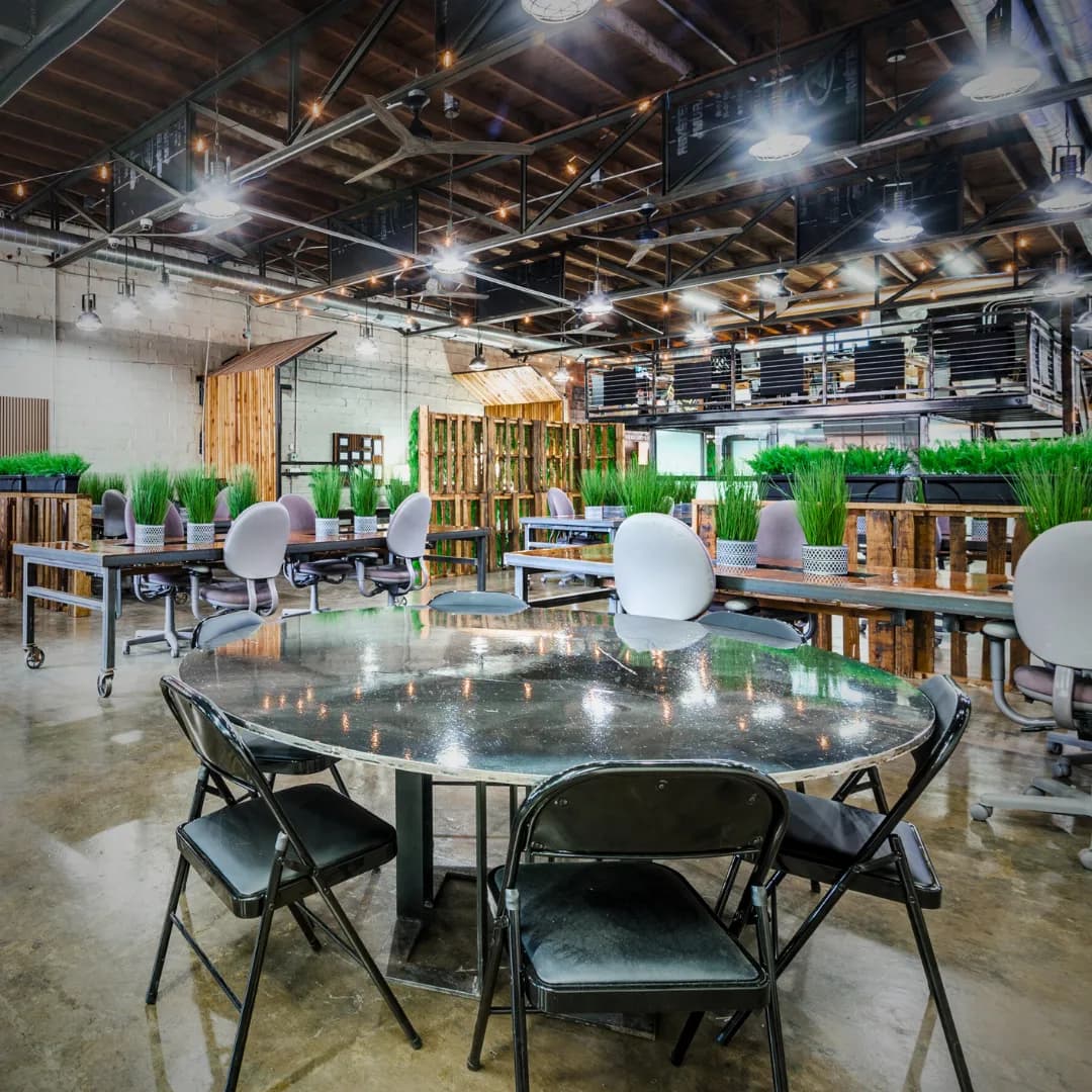 The open coworking floor at REI Workplace, with desks and task chairs under exposed steel beams